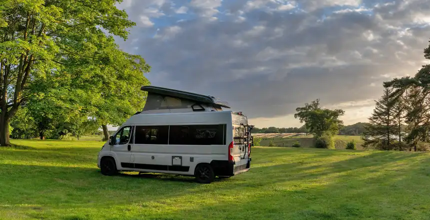 Grauer Campervan auf gr&uuml;ner Wiese